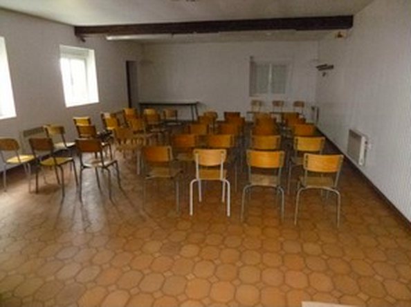 La grande salle de la salle communale de Mamey, avec ses chaises rangées le long des murs.